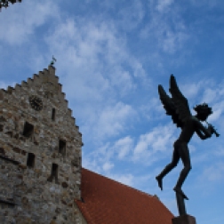 The statue is "Angel with trumpet" by Carl Milles in front of Sankt Nicolai Church in Simrishamn.