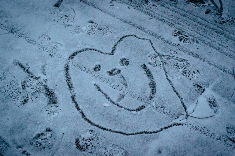 A child has drawn figures in the snow.